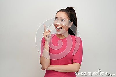 Portrait of a smiling girl pointing finger up at copyspace isolated on a white background Stock Photo