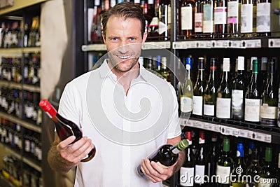 Portrait of a smiling handsome showing a wine bottle Stock Photo