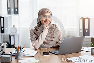 Portrait Of Smiling Islamic Female Entrepreneur At Her Workplace In Office Stock Photo