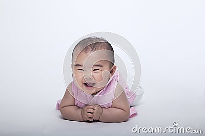 Portrait of smiling and laughing baby lying down, studio shot, white background Stock Photo