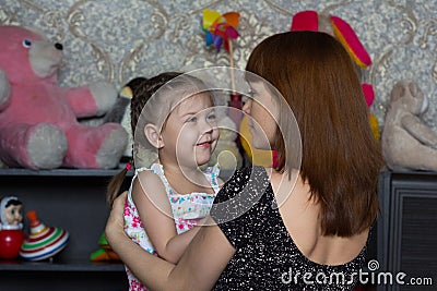 Portrait of smiling little girl and mother looking at each other with soft look and love Stock Photo
