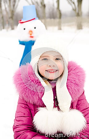 Portrait of smiling little girl with snowman Stock Photo