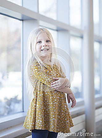 Portrait of smiling little girl wearing yellow frock Stock Photo