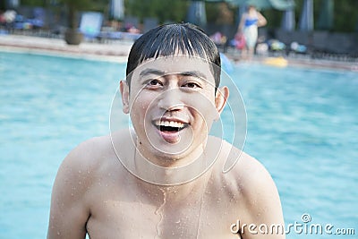 Portrait of smiling man exiting the pool and looking at camera Stock Photo