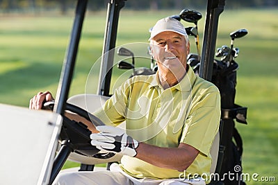 Portrait of smiling mature man driving golf buggy Stock Photo