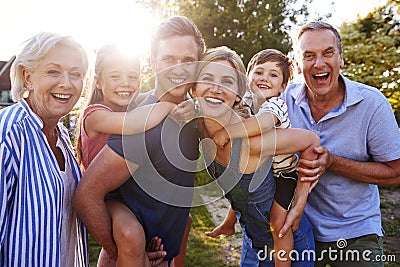 Portrait Of Smiling Multi Generation Family Outdoors In Summer Park Against Flaring Sun Stock Photo