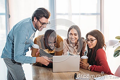 portrait of smiling multicultural business people working on laptop together Stock Photo