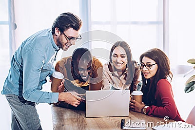 portrait of smiling multicultural business people working on laptop together Stock Photo