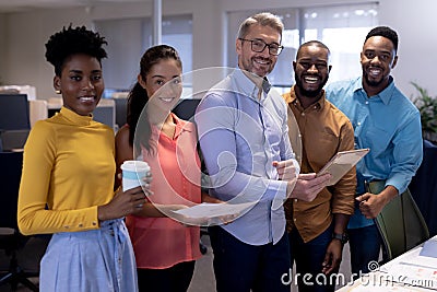 Portrait of smiling multiracial business advisors with document and tablet pc at modern office Stock Photo