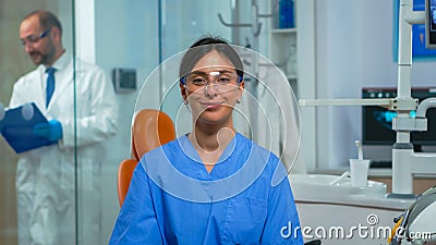 Nurse smiling at camera sitting in dental office Stock Photo