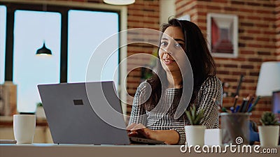 Portrait of smiling remote student typing data on keyboard and taking notes Stock Photo
