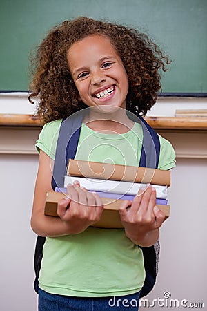 Portrait of a smiling schoolgirl holding her books Stock Photo