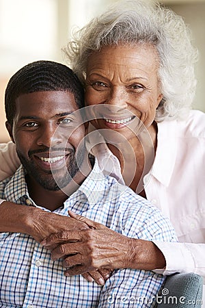 Portrait Of Smiling Senior Mother Hugging Adult Son At Home Stock Photo