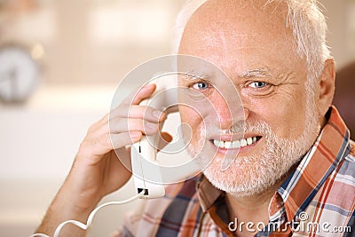 Portrait of smiling senior using landline phone Stock Photo