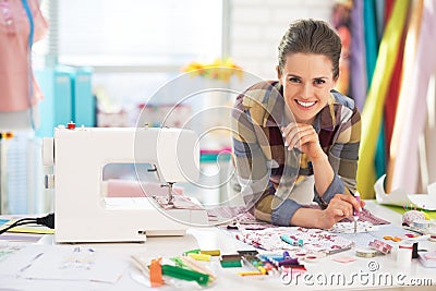 Portrait of smiling tailor near sewing machine Stock Photo