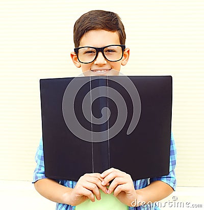 portrait smiling teenager boy in eyeglasses with folder or book Stock Photo