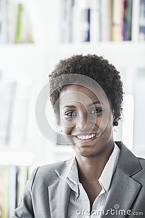 Portrait of smiling young businesswoman with short hair looking at the camera, head and shoulders Stock Photo