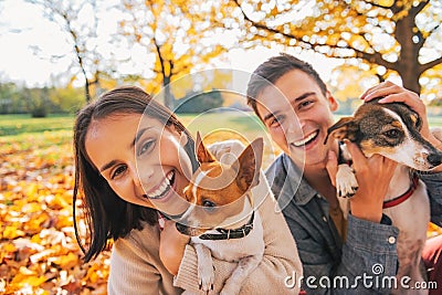 Portrait of smiling young couple with dogs outdoors Stock Photo