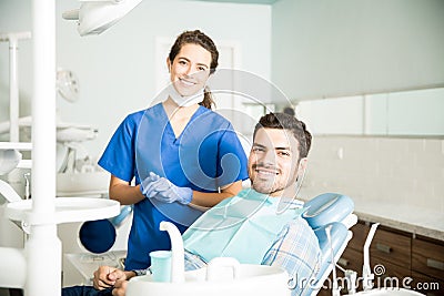 Portrait Of Smiling Dentist And Mid Adult Man In Clinic Stock Photo