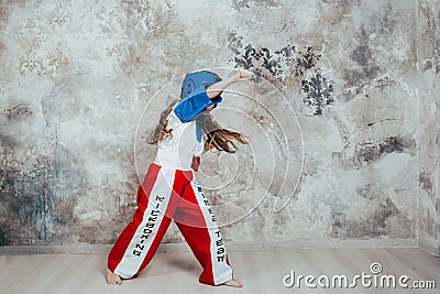 Portrait of a smiling young female taekwondo girl against a grunge wall Stock Photo