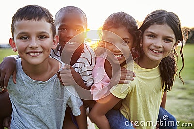 Portrait of smiling young friends piggybacking outdoors Stock Photo