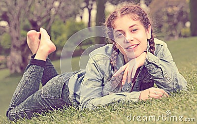 Portrait of smiling young girl while lying in outdoors Stock Photo