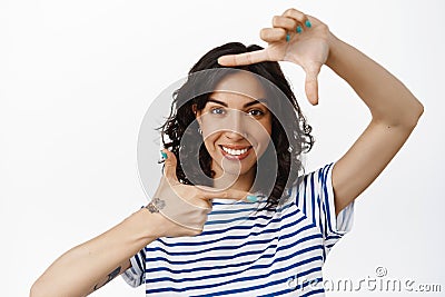 Portrait of smiling young woman make hand frames camera, taking picture, searching perfect spot angle, imaging something Stock Photo