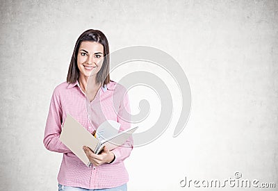 Smiling young woman, copybook, concrete Stock Photo