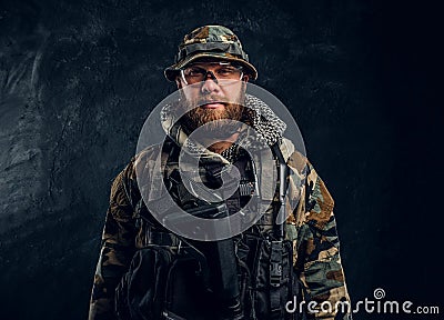 Portrait of a special forces soldier in the military camouflaged uniform, looking at a camera. Stock Photo