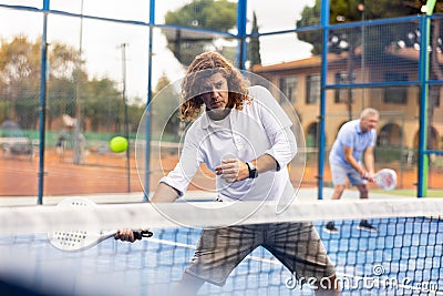 Sporty resolved man playing padel on open court Stock Photo