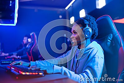 Portrait Streamer African young woman professional gamer playing online games computer, neon color Stock Photo