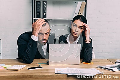 portrait of stressed business people at workplace with documents and laptop Stock Photo