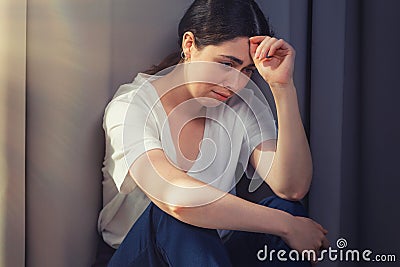 Portrait of a stressed crying woman, clutching her head. The concept of domestic violence Stock Photo