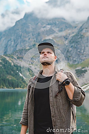 portrait of strong hiker man in front of lake in mountains Stock Photo