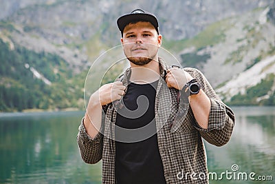 portrait of strong hiker man in front of lake in mountains Stock Photo