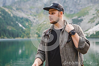 portrait of strong hiker man in front of lake in mountains Stock Photo