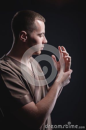 Portrait of a strong and large male masseur in special clothes with a finger at the temple reads your chin and knows all Stock Photo