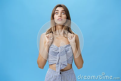 Portrait of stunned speechless and concerned young glamorous female pressing hands to chest popping eyes at camera Stock Photo