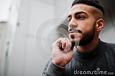 Portrait of stylish arab beard man wear grey turtleneck. Arabian model guy against steel wall Stock Photo