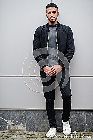 Portrait of stylish arab beard man wear grey turtleneck and black jaket. Arabian model guy against steel wall Stock Photo