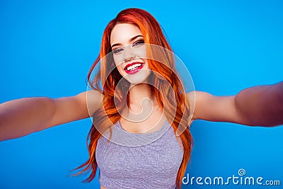 Portrait of stylish funny happy carefree girl with ginger hair,cute face and big breast make selfie photo and laugh while Stock Photo
