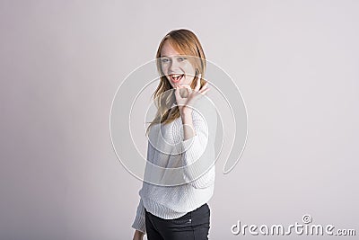 Portrait of a stylish girl on a white background in the studio who shows Okay Agree. Stock Photo