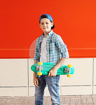 Portrait stylish teenager boy with skateboard in city Stock Photo