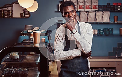 Portrait of successful African American owner small business smiling at camera while standing at the coffee shop. Stock Photo