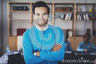 Portrait of successful confident hispanic businessman smiling at the camera in modern office.Horizontal,blurred Stock Photo