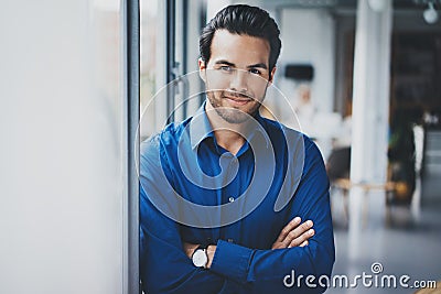 Portrait of successful confident hispanic businessman smiling and standing close from the window in modern office Stock Photo