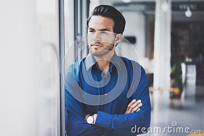 Portrait of successful confident hispanic businessman standing close from the window in modern office.Horizontal,blurred Stock Photo