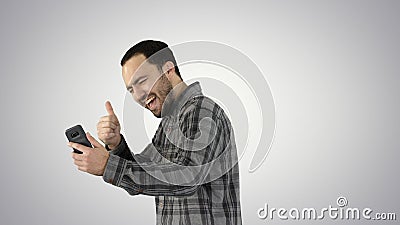 Portrait of successful handsome young man video chating on gradient background. Stock Photo