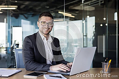 Portrait of a successful male businessman, banker, financial director sitting in the office at the table and using a Stock Photo