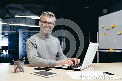 Portrait of successful senior businessman, gray haired man in glasses smiling and looking at camera, mature investor Stock Photo